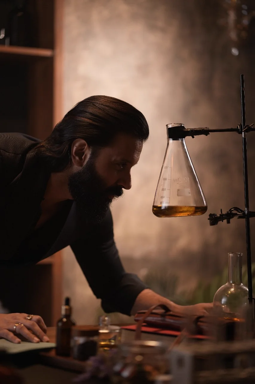 Person working with laboratory glassware in a production scene